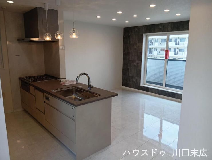 対面式キッチンを備えた居住空間。家事をしながらでも家族とのコミュニケーションを育むことができる機能的な設計です。