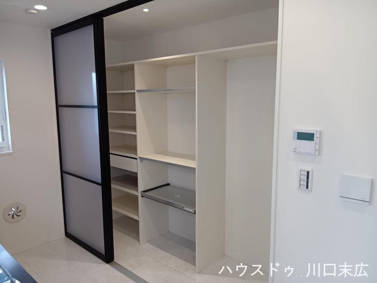 キッチン背面に設けられた大容量のカップボード。機能的な食器棚や家電設置スペースを備え、散らかりがちなキッチン周りをすっきりと美しく整理整頓できます。