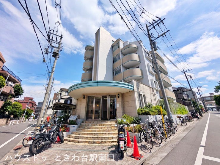 石張りの落ち着きあるエントランス。緩やかな階段と曲線を描くキャノピーが、住まう人を優しく迎え入れます。管理体制の良さを感じさせる、すっきりと整えられたアプローチです。