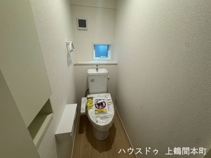 小窓のあるトイレ。白で統一され、トイレットペーパーは壁面収納できます。