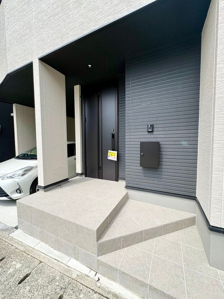屋根付きのゆとりある玄関アプローチで、雨の日も安心して出入り可能です。重厚感のある玄関扉で上質な印象を与えます。