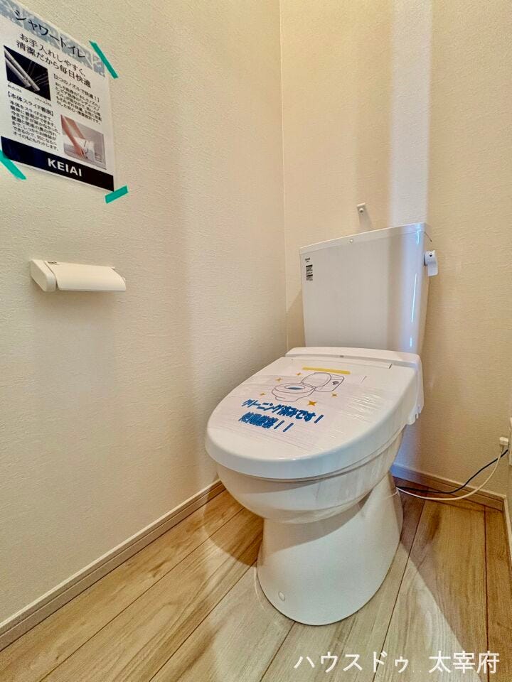 木目調のアクセントクロスと落ち着いた床材が映える、スタイリッシュなトイレ空間です。温水洗浄便座を備え、清潔感とインテリア性を両立させた快適で落ち着けるプライベート空間に仕上がっています。
