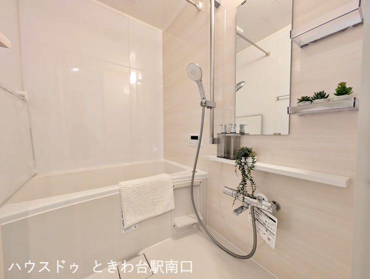 三面鏡タイプの洗面化粧台です。鏡裏に小物を収納でき、横には洗濯機置き場と吊戸棚を配置。効率的な家事動線に配慮した、使い勝手の良いサニタリー空間です。