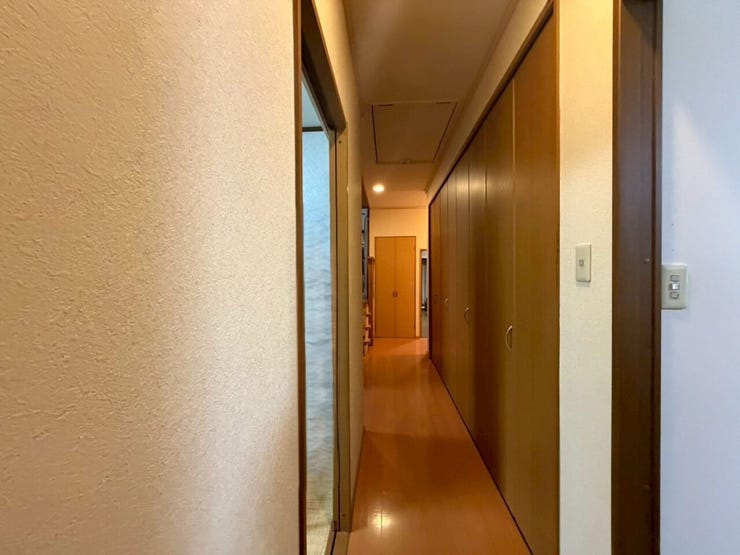 先ほどの洋室から奥の8帖の洋室の方へ向かう廊下です♪右手前がリビングに繋がる入口、大きな押し入れが続き、左側は洗面所への入り口です♪