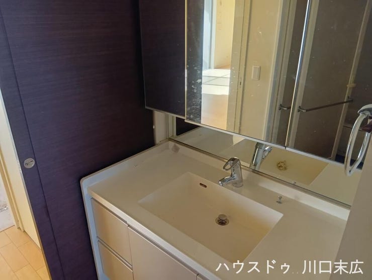大きな三面鏡と豊富な収納を備えた洗面化粧台。鏡裏に小物をすっきりと整理でき、慌ただしい朝の身支度を快適にする機能的な設備です。