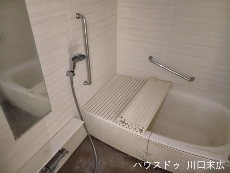 落ち着いた色調のパネルが寛ぎの時間を演出するバスルーム。手すりを備え、家族全員が安心して入浴できるリラクゼーション空間です。