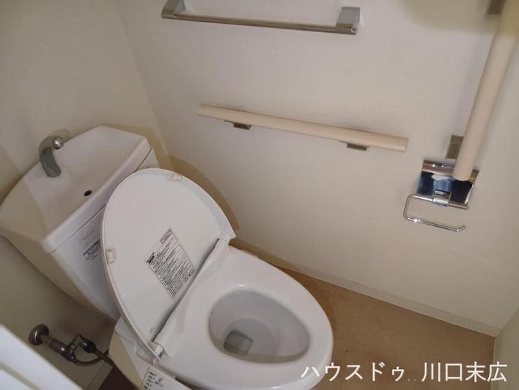 スタイリッシュな手洗い付きの温水洗浄便座を備えたトイレ。手すりを完備しており、安全に配慮された機能的なサニタリー空間です。
