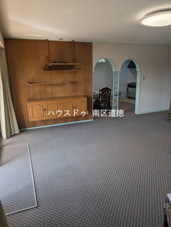 造作収納や飾り棚が設けられ、上質な住まいを演出します。アーチ型の開口部が印象的で、来客時にも映えるデザイン性の高い室内です。