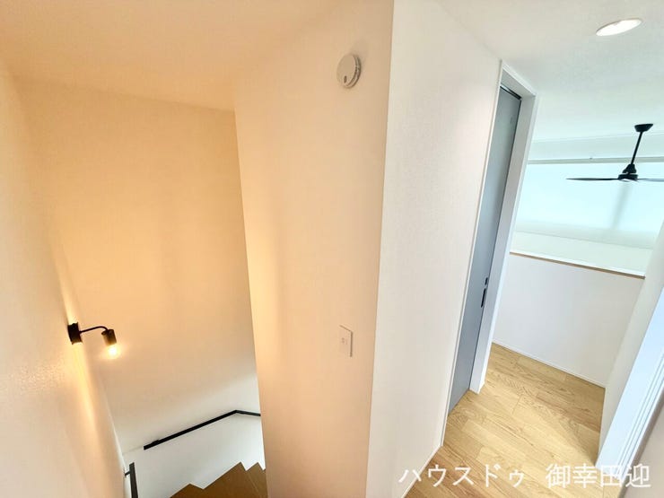 ■暮らしを繋ぐ、明るい動線■階段吹き抜けと奥の開放的なスペースを望む。シーリングファンが見える明るい空間です。
