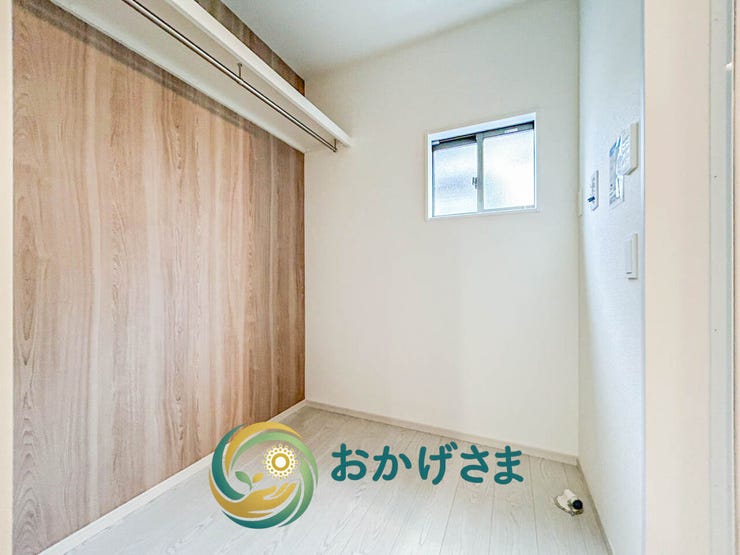 温かみのある木目調のアクセント壁が映える、便利なハンガーパイプと小窓を配した明るい洋室です。