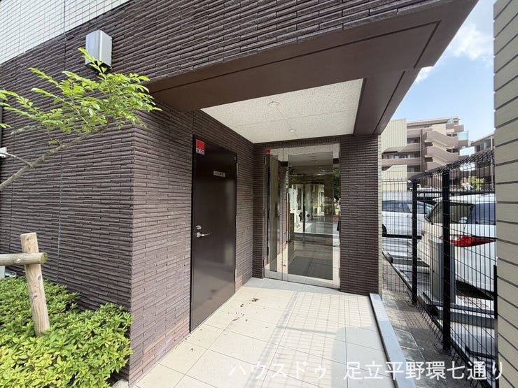 植栽を配した落ち着きあるエントランス。屋根付きのアプローチで、雨の日も出入りしやすい設計です。