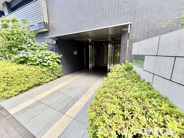 植栽に彩られたアプローチが迎えるエントランス。落ち着きと清潔感のある共用部です。