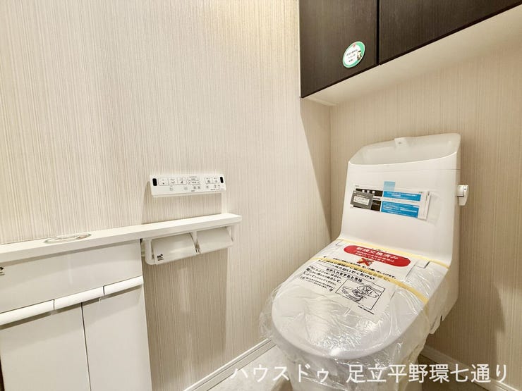 上部収納付きのトイレは生活感を抑えてすっきり。温水洗浄便座付きで快適に使えます。