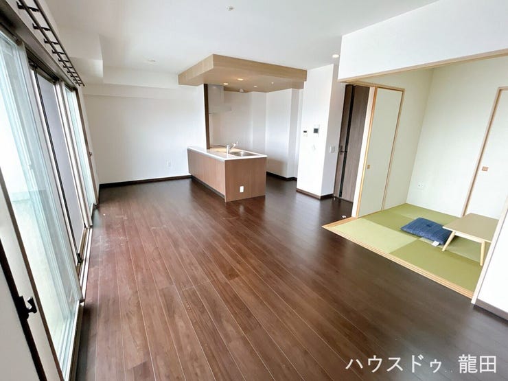 ダークブラウンの床と木目調天井が美しいLDK。家族の会話が弾む対面式キッチンを中心とした広々空間