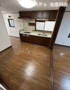 深みのあるブラウンの木目調パネルがシックな、大容量収納付きのシステムキッチン。お料理に集中しやすい壁付けタイプで、リビングを見渡せる開放感と、家事動線の良さを両立した設計です。