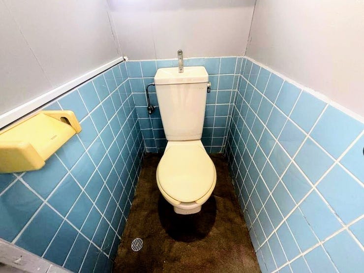 レトロなブルーのタイルがアクセント。清潔に整えられたトイレスペース