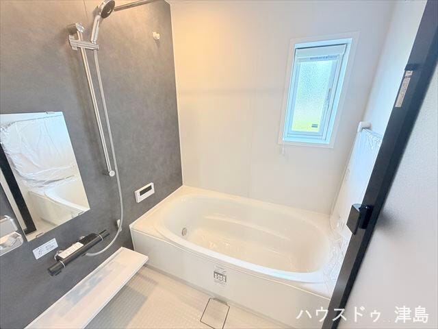 シックな雰囲気のくつろぎスペースの浴室。浴室乾燥機が設置され、雨の日でも洗濯物を干すのに助かります。