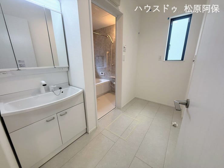 三面鏡付きの機能的な洗面化粧台を設置。洗面室には小窓があり、換気もしやすく明るい空間です。浴室へとスムーズに移動できる使い勝手の良い動線となっています。