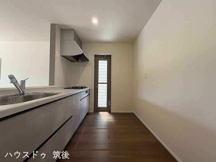 【勝手口付きのキッチン】ゴミ出しや換気、一時的な荷物の搬入に便利な勝手口を設けています。自然光が差し込み、明るく衛生的な調理スペースです。スタイリッシュなシステムキッチンで毎日のお料理も快適に。