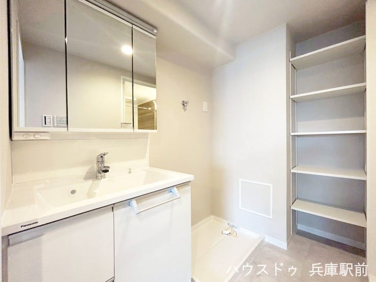 三面鏡付き洗面化粧台と収納棚を備え、使いやすさに配慮された洗面室です。