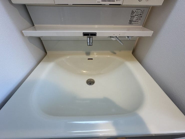 洗面台は、水栓まわりに水がたまりにくい壁出しタイプのシャワー水栓が魅力。一体型ボウルは継ぎ目がなく、さっと拭くだけでお手入れが簡単。上部棚も小物の整理に重宝します。