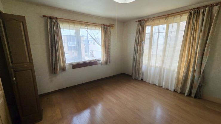 【居住中のため家具削除し、CGで加工した室内写真】ゆったりとした広さがある二階約8畳の洋室です。2方向の窓から心地よい光と風が入り込み、毎朝を気持ちよく迎えられます。