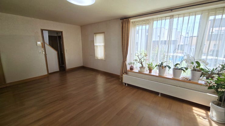 【居住中のため家具削除し、CGで加工した室内写真】奥の扉から廊下や階段へとスムーズに繋がっており、すっきりとした空間で好みに合わせたリビングスタイリングを楽しめます。