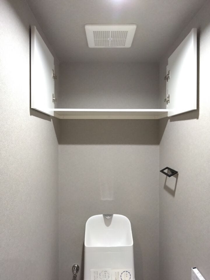 上部収納付きのトイレ。トイレットペーパーや掃除用品をすっきり収納でき、空間を美しく保てます。