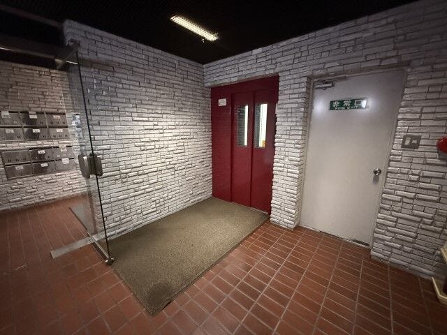 白レンガ調の壁面とテラコッタ風タイルが美しく調和した、味のある上品なロビー空間
