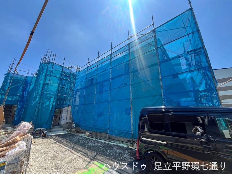 建築工事が進行中。青空の下で新しい住まいの完成が待ち遠しい現地です。