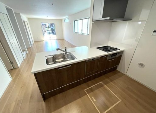 家族の会話が自然と弾む、対面式のオープンカウンターキッチンを備えた大空間のLDKです。お料理中もリビング全体を見渡せ、明るい光が差し込む広々としたフロアで、心地よくリラックスした時間を過ごせます。