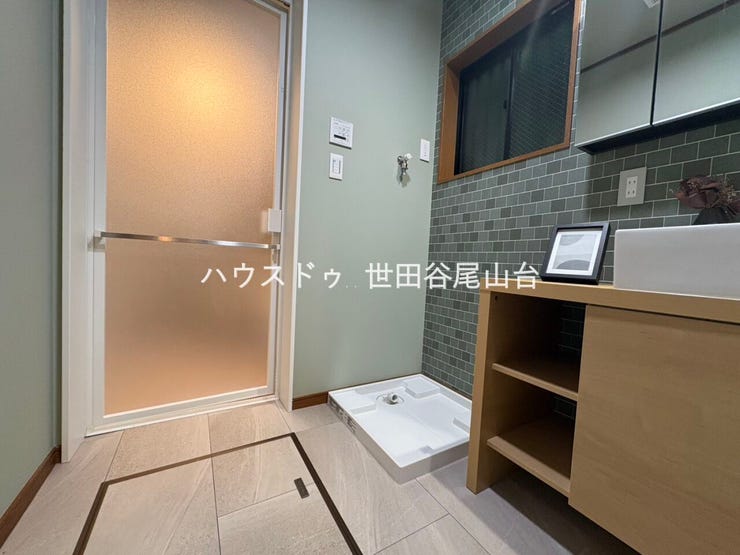 落ち着いたアクセントクロスが印象的な洗面室。収納棚付きの洗面化粧台を採用し、使い勝手とデザイン性を両立しています。