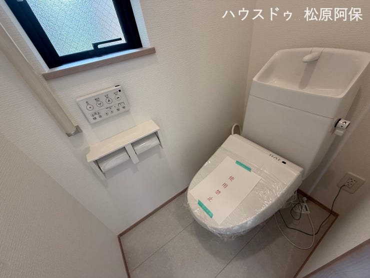 清潔感あるホワイトでまとめられた、先進の高機能温水洗浄便座付きトイレです。便利な手洗い器やペーパーホルダーを完備。