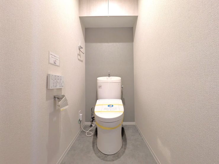 ■温水洗浄便座付きトイレ■
白を基調とした内装に、おしゃれなアクセントクロスが映える落ち着いた空間です。上部にはトイレットペーパーなどのストックをスッキリ隠して収納できる、扉付きの棚を備えています。