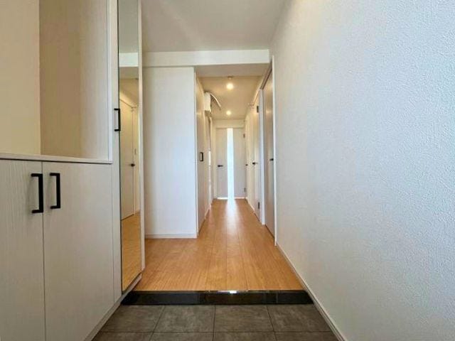 扉を開けると白基調のホールが奥行きを感じさせます。各部屋の扉を閉めることでプライベート部分はみえないのが◎