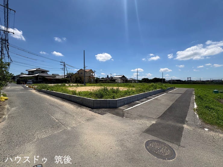 【11号地:前面道路含む現地写真】道路に面した開放的な配置で、陽当り・通風ともに良好な住環境です。周辺は高い建物がなく空が広くのぞくロケーション。