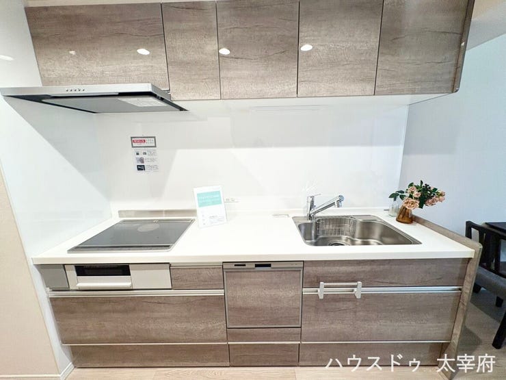 すっきりした木目調のデザインで、調理スペースが広々と使えます。IHクッキングヒーターやビルトイン食洗機を備え、収納力も抜群で家事効率を高める使い勝手の良いシステムキッチンです。