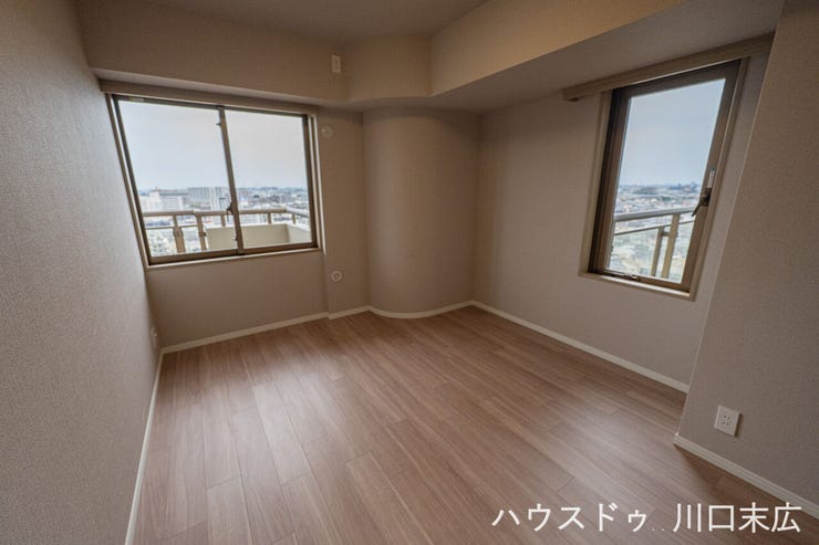 都市の風景を望む洋室。温かみのある木目調のフローリングを採用し、寝室や趣味の部屋など、ライフスタイルに合わせて自在にレイアウトを楽しめるプライベート空間です。