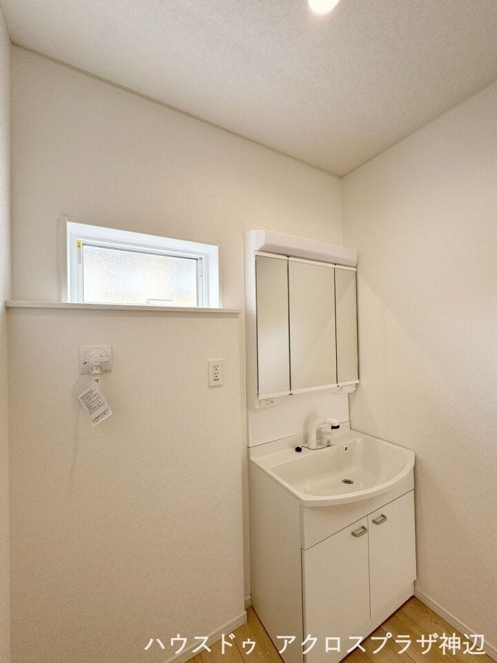 【洗面脱衣所】白を基調とした爽やかな洗面スペース。身支度に便利な三面鏡には小物をすっきり収納できます。高めの位置に配置された窓からは心地よい自然光が入りプライバシーを守りながら換気もスムーズ。