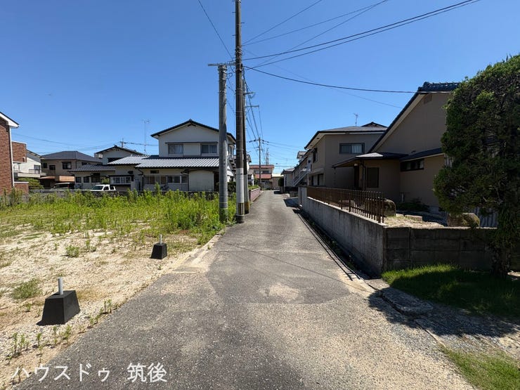 【建築条件なし】前面道路(幅員約4m)と敷地の位置関係が分かりやすい現地写真です。道路沿いは平坦で、お好みのハウスメーカーや工務店にて自由に建築プランをご検討いただけます。
