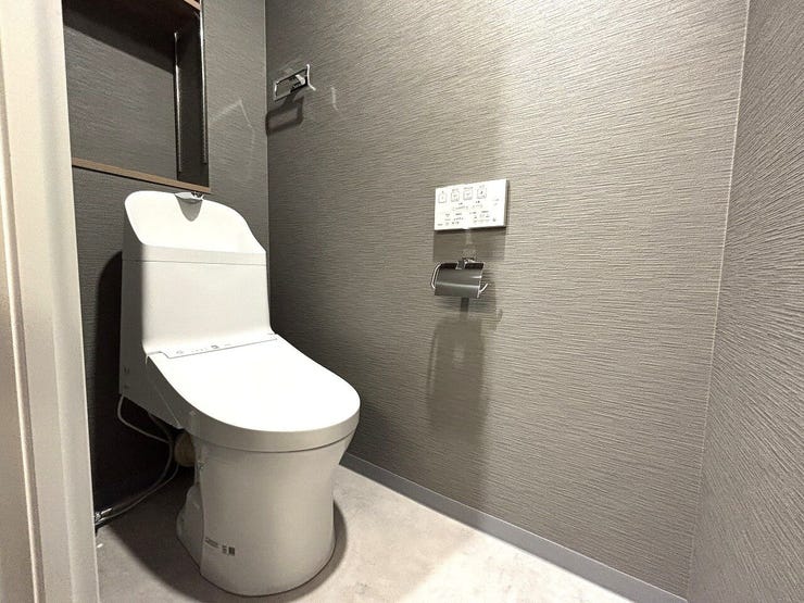 スタイリッシュな手洗い一体型トイレ。奥には小物をすっきり飾れる便利な棚付きです。