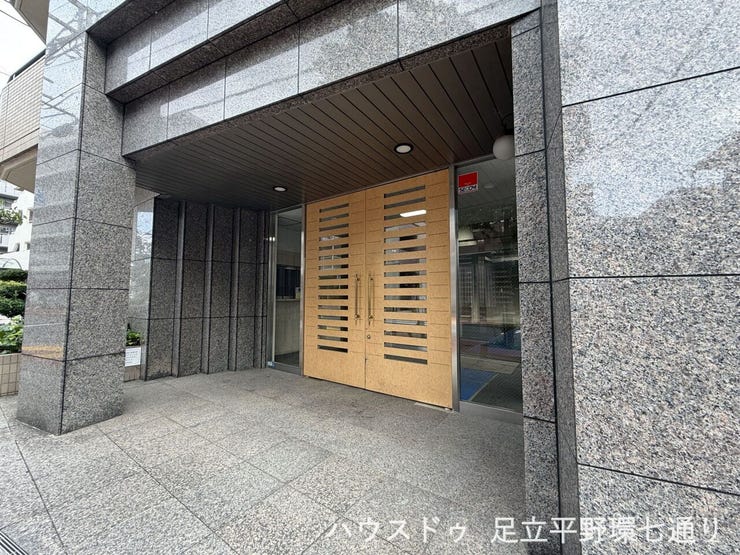 木目調の扉と石張りの壁が印象的な、品格のあるエントランスです。