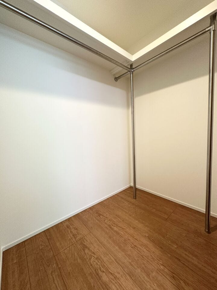 約8.0帖の寝室にあるウォークインクローゼット。
ハンガーパイプが広く配されており、衣類をたっぷり掛けられます。上部の棚や足元も有効に使え、スーツケースなどの大きな荷物もすっきり収まるサイズ感です。