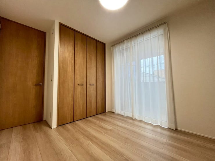 約5帖洋室
木目調の床と建具で構成された洋室です。壁面に幅の広いクローゼットが設けられ、衣類等を整理する収納設備が整っています。掃き出し窓により光を取り込める設計です。