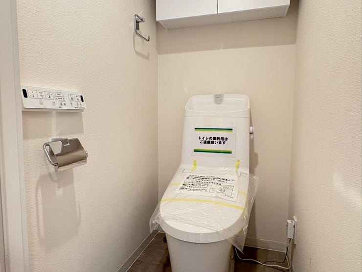 温水洗浄便座付きで、毎日を快適に過ごせる清潔なトイレです。頭上の棚にはトイレットペーパーや掃除用品をすっきりと収納可能。白を基調としたシンプルな空間は、落ち着いた雰囲気が感じられます。