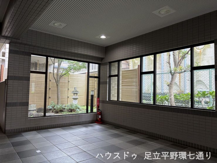 開放的な窓から光が差し込むエントランスは、住まいの顔として落ち着いた空間です。