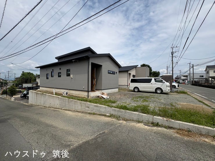 【A棟:北西側道路含む外観】北西側(幅員約4.3m)の道路側から見たA棟の外観です。高低差に配慮した土留めが施工されており、敷地全体がすっきりと美しく収まっています。