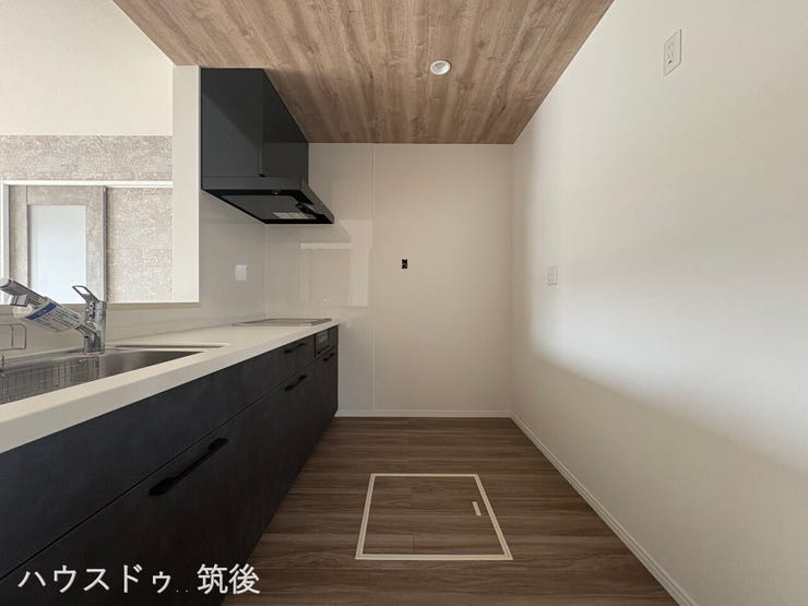 【ゆとりあるキッチン空間】木目調の天井クロスがおしゃれなキッチン。背後には冷蔵庫やカップボードを配置できる十分な広さを確保しています。床下収納も備わっており、保存食などのストックにも便利です。