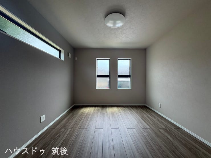 【主寝室6.75帖】落ち着いたグレーのアクセントクロスを施したお部屋です。スクエア型の並び窓と横長スリット窓から心地よい光が差し込み、外からの視線にも配慮されたプライバシー性の高い空間です。