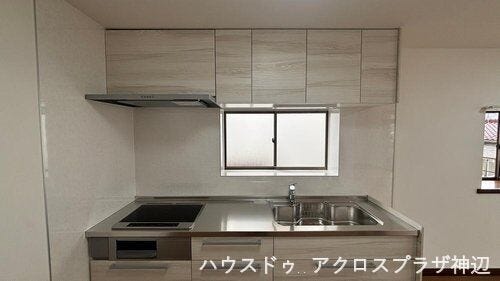 【キッチン】淡い木目調のデザインが空間に溶け込むシステムキッチンです。火を使わず安全でフラットな天板はお掃除もサッと拭くだけ。正面には窓があり、調理中の換気がスムーズです。